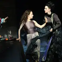 Poster design titled &ldquo;Salome&rdquo;: Two historical, sepia-toned stage figures in the foreground&mdash;one person in Roman-style armor holding a sword and another person standing on a pedestal. A dark green and black, painterly background